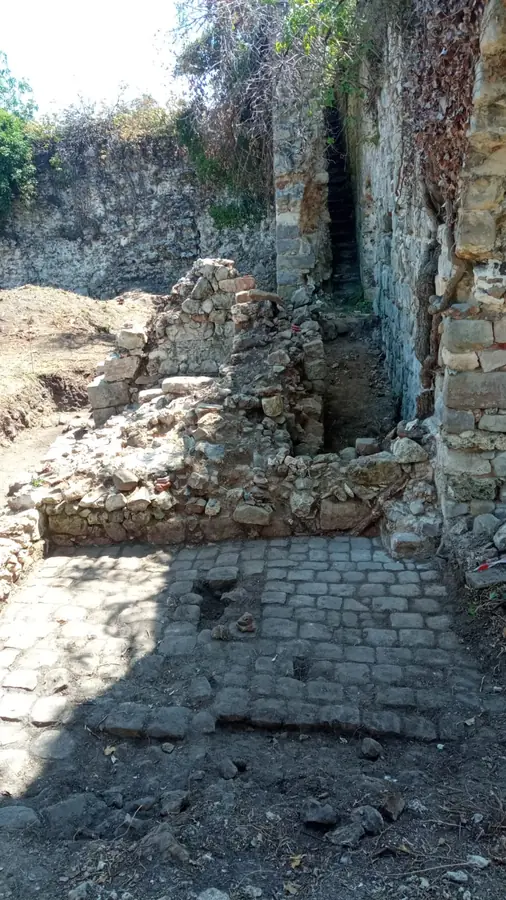Sol pavé et maçonneries dégagés au pied de l'enceinte de la forteresse