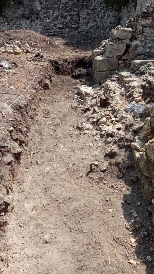 Tranchée de fouille ouverte le long d'un mur en pierre