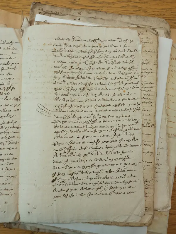 Liasse de feuillets manuscrits anciens empilés